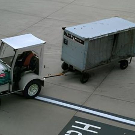 Ein Flughafenfahrzeug mit einem Anhänger auf der Flugbahn