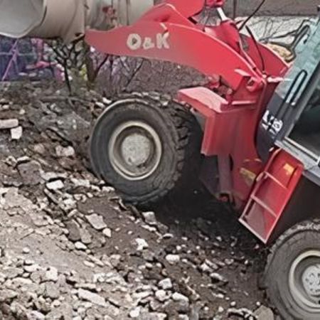 Ein roter Bagger mit großen Reifen auf einer Baustelle