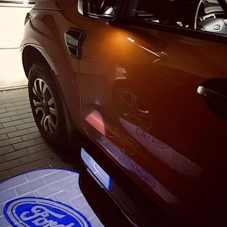 Ein orangener Ford in der Werkstatt mit Lichtsymbol