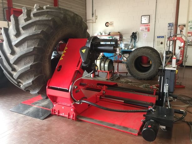 Reifen eines Nutzfahrzeuges in einer Werkstatt auf einer großen roten Maschine